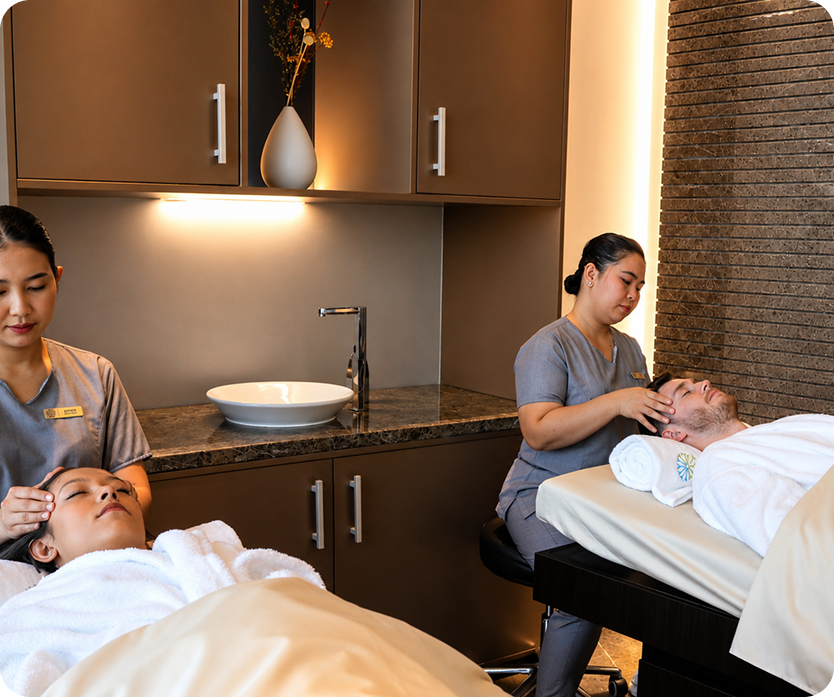Couples massage with two therapists in a serene treatment room